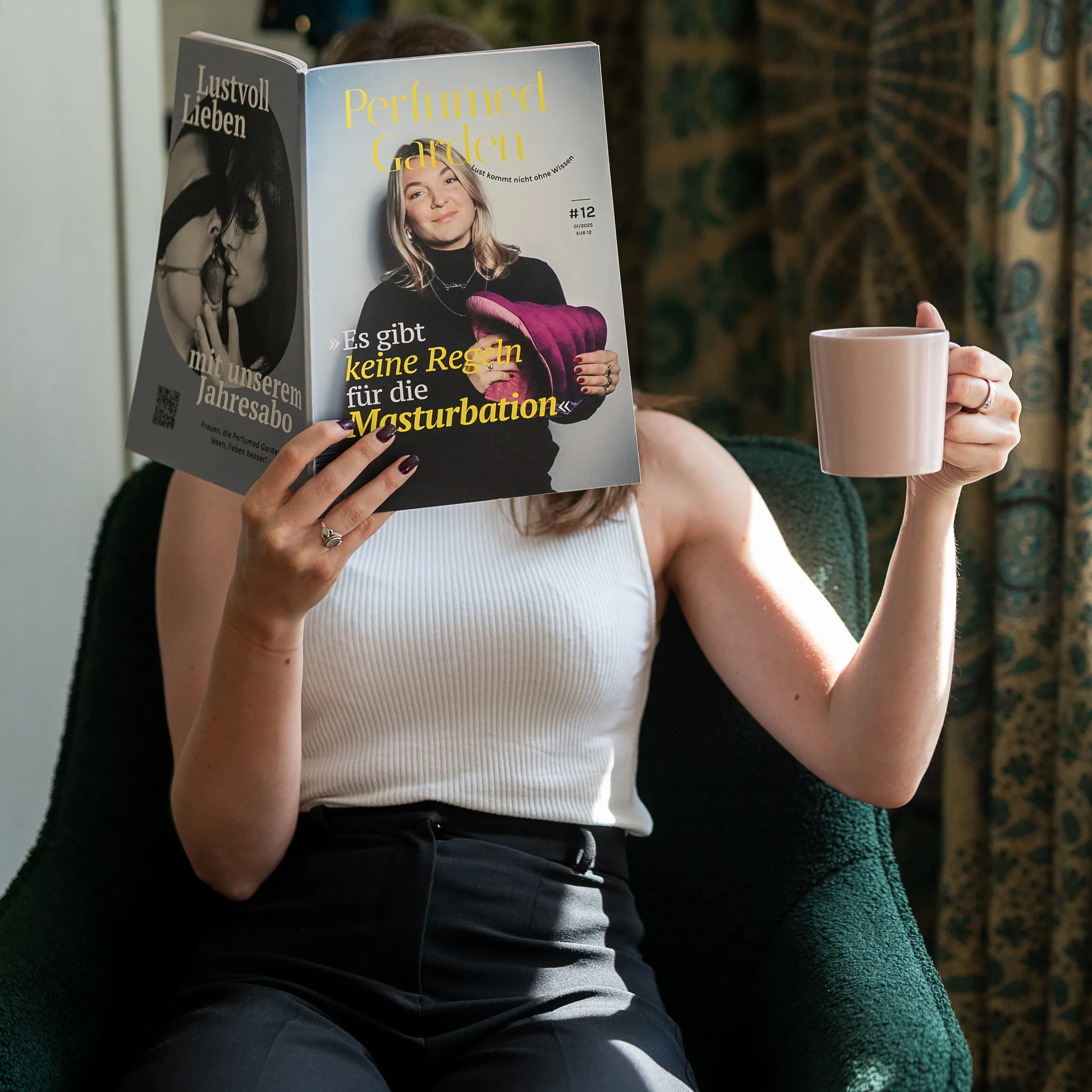 Leserin im Sessel mit Magazin und Kaffeetasse