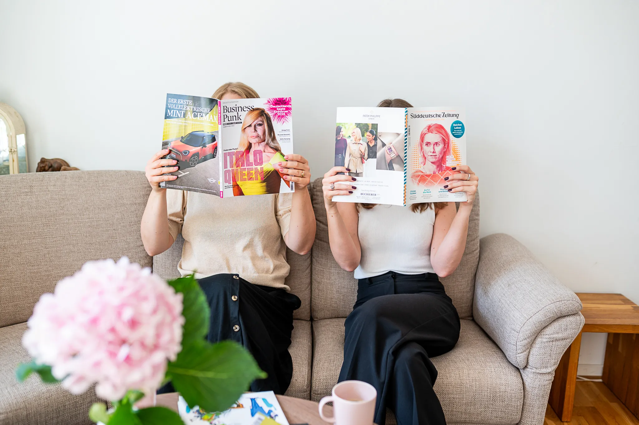 Marie Franz und Sophia Lock lesen Magazine auf dem Sofa